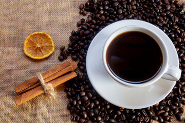 Black coffee in a white cup on a light brown cloth in the evening