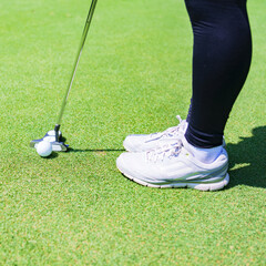 putter and golf ball on the green