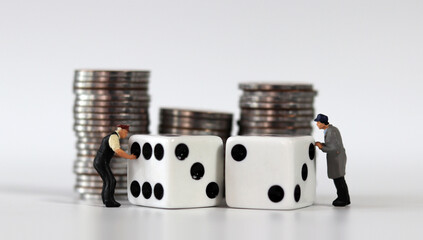 Pile of coins and two white dice. Miniature people and business concept.
 - obrazy, fototapety, plakaty