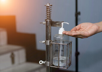 female hand using alcohol gel to wash hands Before starting work to prevent the spread of COVID-19.