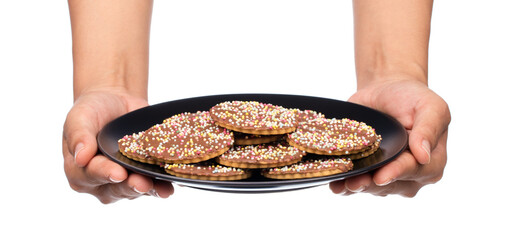 hand holding chocolate cookies sprinkle on dish isolated on white background.