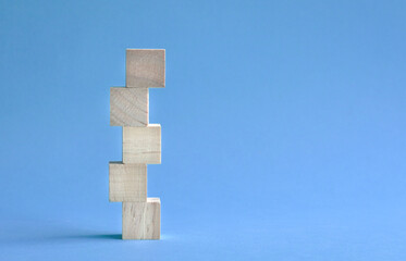 5 letter blank and wood block stacked up. On blue background. Copy space.