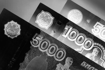 Russian banknotes 5000, 1000 and 500 rubles close-up. Dark black and white illustration about...