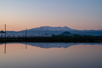 春の比布町 夜明け前の田んぼと大雪山の風景
