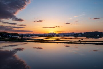Fototapeta na wymiar 春の当麻町 夕焼けと田んぼの風景 