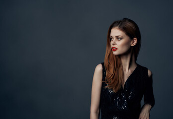 pretty woman in black dress posing on dark background luxury