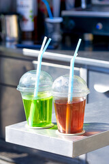Street vendor of various drinks poured into transparent plastic cups