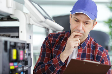 technician is checking and changing the printer equipment cartridges