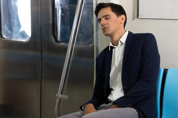 male businessman sleeping inside the subway train