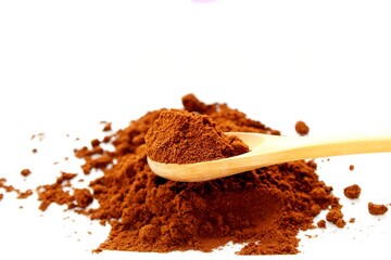 Spoon full of ground coffee, white background
