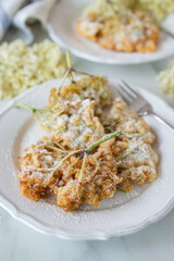 Sweet home made fried elderflowers in pancake on a table