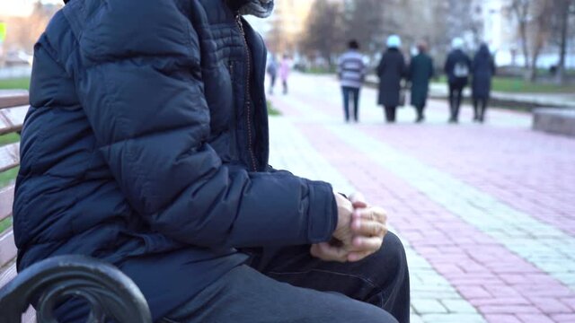social problems concept. Hands of a pensioner close up. Financial difficulties. An elderly man rubs his hands from the cold in the park during the day. The pensioner needs help