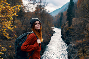 sunny tourist near river mountains autumn forest landscape