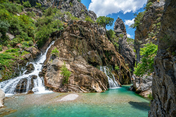 Fototapeta na wymiar Uçansu Waterfall, which is born in Gündoğmuş district at the summit of the Taurus Mountains and is approximately 50 m high, is known as the ‘hidden paradise in the forest.’