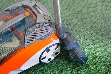 washing vacuum cleaner on the background of a green carpet