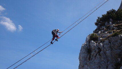 Via ferrata Donnerkogel Intersport klettersteig in Austrian Alps, Climber on 40 metres long ladder...