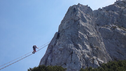 Via ferrata Donnerkogel Intersport klettersteig in Austrian Alps, Climber on 40 metres long ladder...