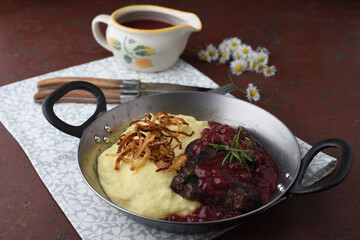 Deer goulash with mashed potatoes and fried onion rings