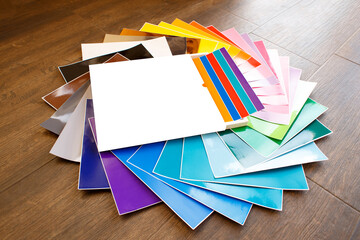 Twisted pile of colorful 12x12 sheets of adhesive paper isolated over the white background.