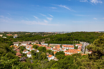 Fototapeta na wymiar Elevated view of south part of city of Gothenburg in spring on a clear day. Residential buildings surrounded by lush tree landscape.