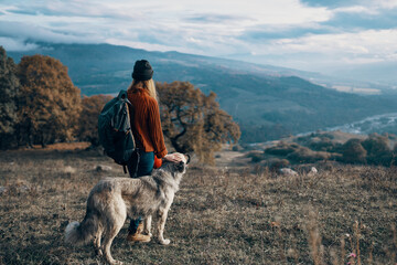 woman hiker nature mountains travel next to the dog freedom friendship