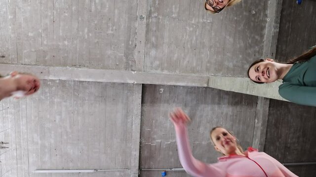 Group or team of happy young sportive women in a gym all cheering with hands up and applauding. High quality FullHD footage