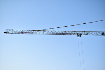 Yellow tower crane its boom is a building under construction