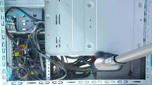 Worker clean PC case with equipment units from dust or dirt with vacuum cleaner