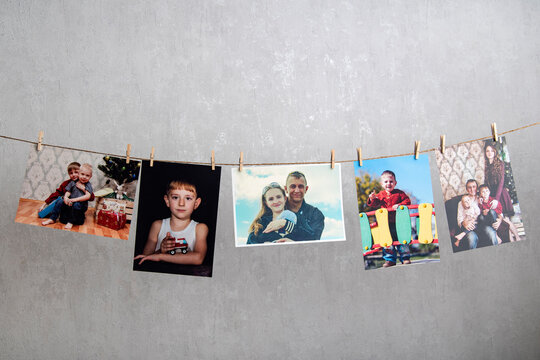 Family photo cards hang on rope. Memories. Home photo gallery, original photo exhibition. Best moments