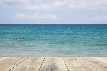 Wooden plank and clear blue water in the background
