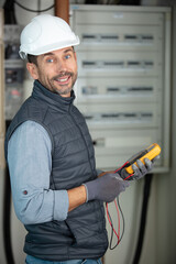 electrician using electric actuator equipment in fuse box