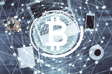 Blockchain theme hologram drawings over computer on the desktop background. Top view. Multi exposure. Concept of cryptoeconomy.