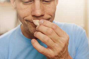 Fototapeta premium Man smelling garlic, this test result means he is healthy