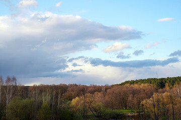 Obraz premium Spring landscape with beautiful sky, forest and river