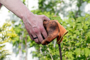Handshake. A man's hand and a dirty glove. The concept of assistance in cleaning the territories of parks and vegetable gardens.