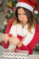 woman getting frustrated wrapping a christmas present
