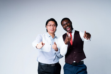 African american and asian businessmen in suits smiling happily pointing fingers at camera