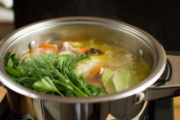 Adding herbs, bay leaves and seasonings to the broth