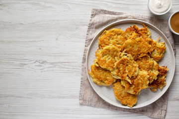 Homemade Potato Pancakes Latkes with Apple Sauce and Sour Cream on a white wooden table, top view. Flat lay, overhead, from above.