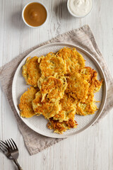 Homemade Potato Pancakes Latkes with Apple Sauce and Sour Cream on a white wooden background, top view. Flat lay, overhead, from above.