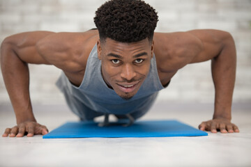 fitness guy training on exercise mat in his own livingroom