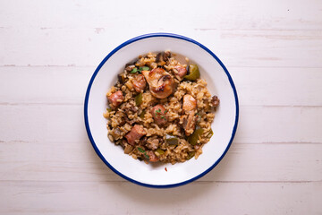 Spanish paella with rabbit, sausages, vegetables and artichokes. Traditional recipe from the Mediterranean area.