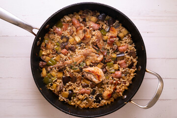 Spanish paella with rabbit, sausages, vegetables and artichokes. Traditional recipe from the Mediterranean area.