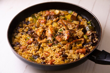 Spanish paella with rabbit, sausages, vegetables and artichokes. Traditional recipe from the Mediterranean area.