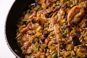 Spanish paella with rabbit, sausages, vegetables and artichokes. Traditional recipe from the Mediterranean area.