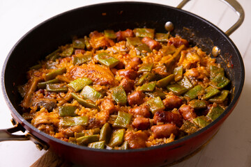 Spanish paella with rabbit, sausages, vegetables and artichokes. Traditional recipe from the Mediterranean area.
