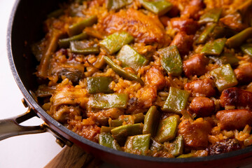 Spanish paella with rabbit, sausages, vegetables and artichokes. Traditional recipe from the Mediterranean area.