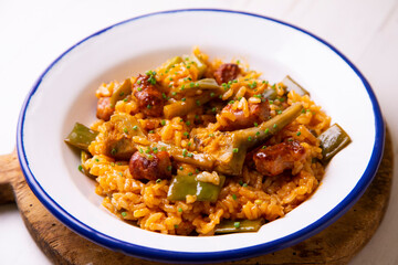 Spanish paella with rabbit, sausages, vegetables and artichokes. Traditional recipe from the Mediterranean area.