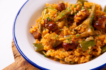 Spanish paella with rabbit, sausages, vegetables and artichokes. Traditional recipe from the Mediterranean area.