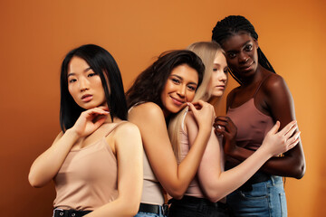 Obraz premium young pretty asian, caucasian, afro woman posing cheerful together on brown background, lifestyle diverse nationality people concept